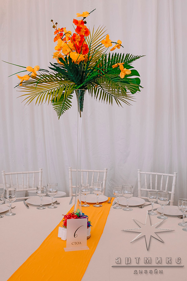 Фото в материал Оранжевые цветы в высоких вазах в оформлении зала