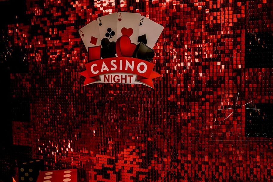 Фотозона из красно-чёрных пайеток в оформлении корпоративной вечерники в стиле "Казино"